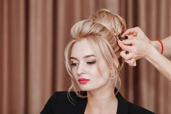 Mulher loira beleza no salão de cabeleireiro fazendo uma noite ou casamento estilo de cabelo — Fotografia de Stock