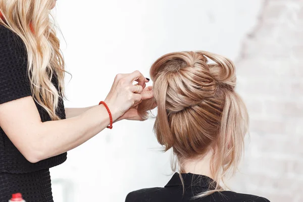 Mulher loira beleza no salão de cabeleireiro fazendo uma noite ou casamento estilo de cabelo — Fotografia de Stock