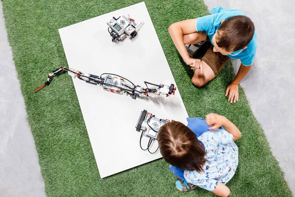 Two young boys playing with robots, educational and playing concept