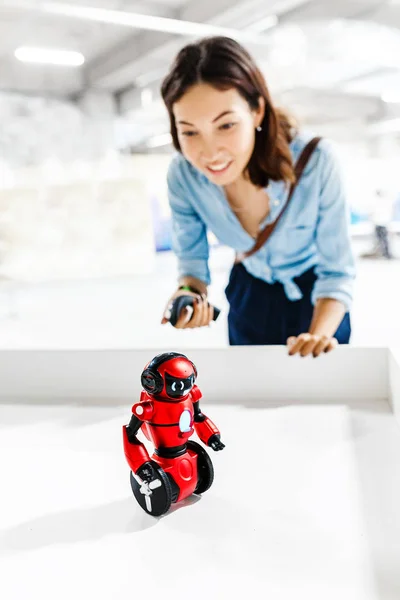 Jeune femme adulte regardant le robot jouet à l'exposition — Photo