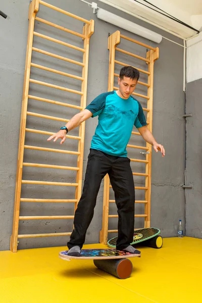 Amateur atleet uit te oefenen op een bord voor evenwicht bij indoor fitness gym, moderne sport concept — Stockfoto