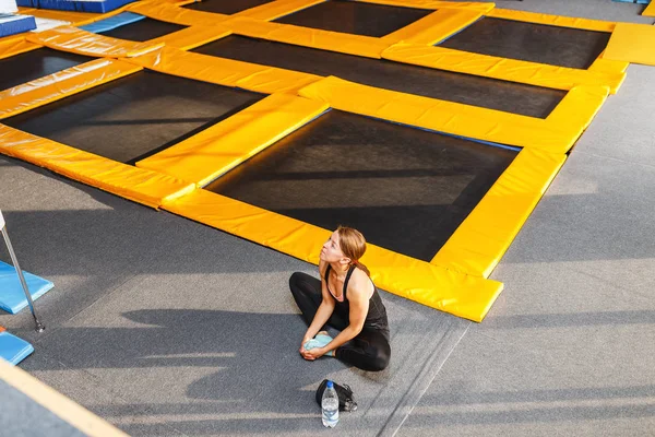 oturma ve trambolin üzerinde biraz egzersiz yaptıktan sonra dinlenme spor giyim güzel genç kadın