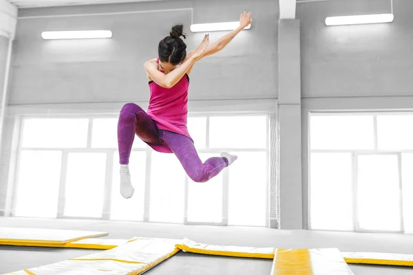 Σύγχρονη γυναίκα hip-hop χορεύτρια άλματα και να κάνει το κτύπημα στο τραμπολίνο γυμναστήριο γυμναστήριο — Φωτογραφία Αρχείου