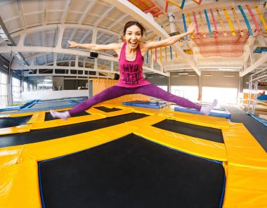 Pratik ve bir kapalı spor salonu, egzersiz ve modern eğlence kavramının trampolines üzerinde atlama neşeli ve mutlu kadın