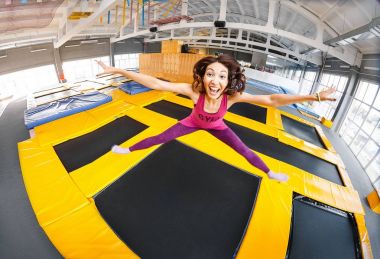 Pratik ve bir kapalı spor salonu, egzersiz ve modern eğlence kavramının trampolines üzerinde atlama neşeli ve mutlu kadın