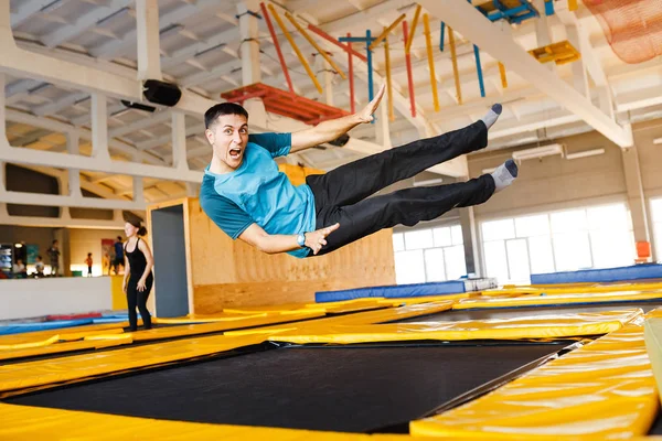 Lycklig känslomässiga man hoppa och flyga i trampolin sportcenter inomhus — Stockfoto