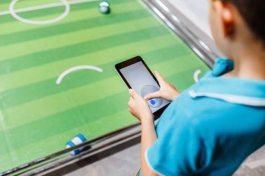 Robotlar tarafından futbol oynayan çocuk uzaktan kumanda için Tablet PC'yi kullanma