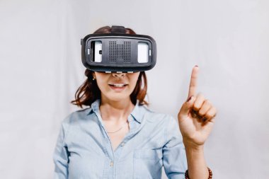 Heyecanla oynarken ya da sanal gerçeklik Vr kask içinde çalışan bir kadın.