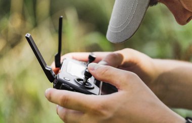 closeup dron işleç açık havada bir amatör quadcopter uzaktan kumanda joystick ile erkek ellerinde