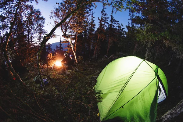 Tourist camp with a tent and a fire at night in the forest, shot on a fisheye lens — Stock Photo, Image