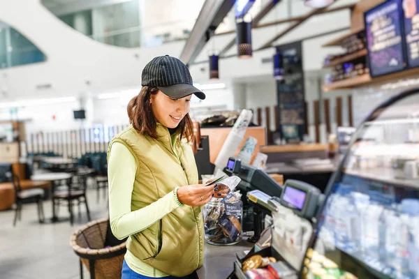 Νεαρή γυναίκα πελάτης πληρωμή με πιστωτική κάρτα σε ένα κατάστημα καφέ — Φωτογραφία Αρχείου