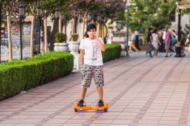 Istanbul, Türkiye - 10 Eylül 2017: hoverboard veya gyroscooter park ve cep telefonuyla konuşurken sürme genç çocuk
