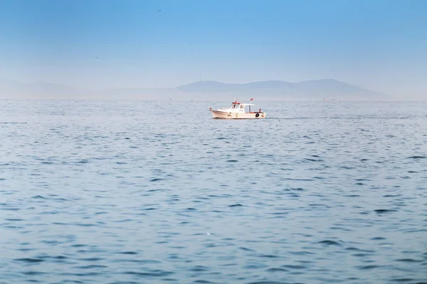 Kleines Boot in einem blauen endlosen Meer mit Kopierraum — Stockfoto
