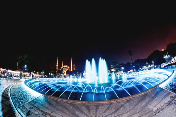 Colorida fuente iluminada en el fondo de la Mezquita Azul Sultanahmet en Estambul, Turquía — Foto de Stock