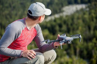 Modern bir akıllı çeyrek helikopter robot orman yoluyla uzun bir yürüyüş sırasında bir adam başlattı