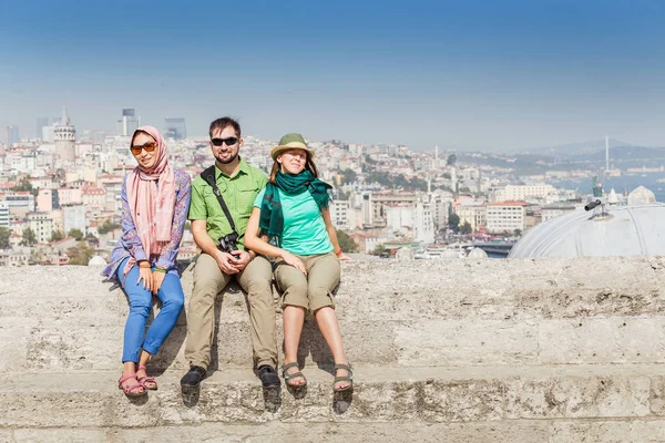 Gruppe fröhlicher Freunde verschiedener Rassen, die in der Nähe der Moschee sitzen und die Aussicht auf Istanbul genießen, Türkei — Stockfoto