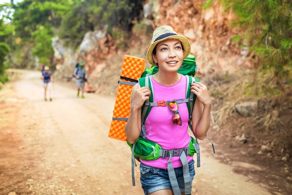 Grupo multinacional de jóvenes amigos felices estudiantes que viajan a lo largo del sendero de Lycian con mochilas en la carretera costera en el bosque. Senderismo y trekking en Turquía concepto — Foto de Stock