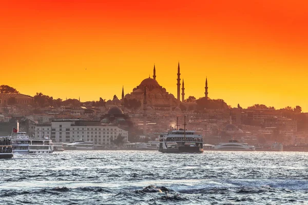 Ferries de pasajeros y barcos transportan personas a través del Estrecho del Bósforo en Estambul al fondo de una mezquita y puesta de sol — Foto de Stock