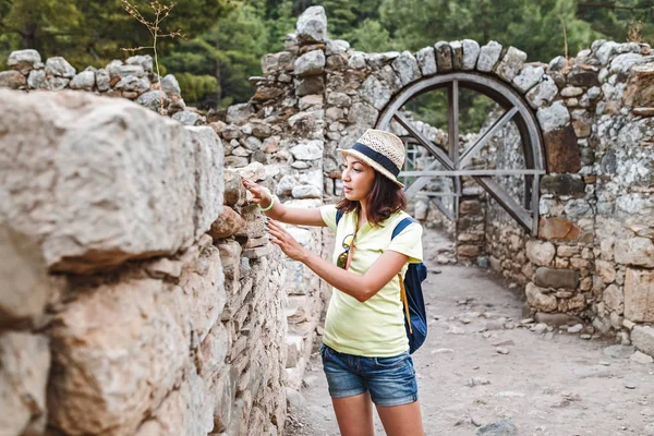 Joven turista femenina con mochila azul explorando la antigua ciudad griega Olympos, cerca del pueblo de Cirali en Turquía — Foto de Stock