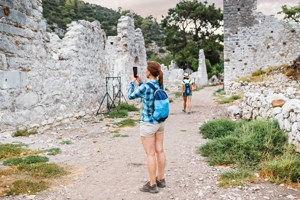 Fiatal női turista a kék hátizsák felfedezése ókori görög város Olympos, Törökország Cirali falu közelében — Stock Fotó