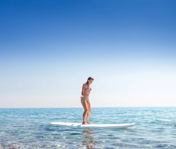 Attraktive Frau auf einem Surf-Boarding im Meer, Lernen und Neuling-Konzept — Stockfoto