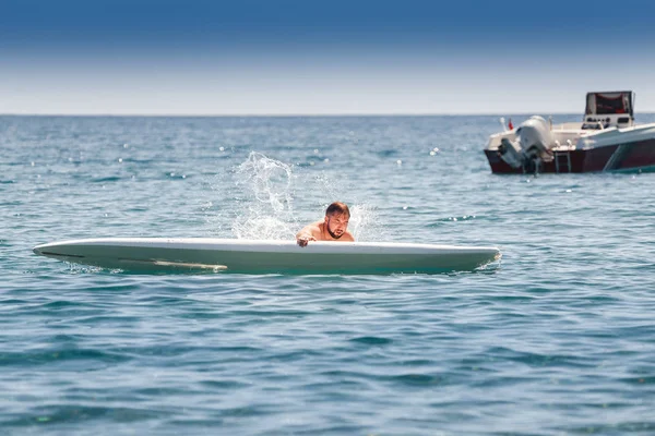 Nowicjusz początkujący surfer spada z planszy podczas treningu na morzu — Zdjęcie stockowe