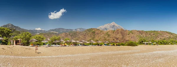 15 SEPTIEMBRE 2017, CHIRALI, TURQUÍA: Soleado complejo de playa en Turquía con impresionantes vistas de las montañas y tumbonas con turistas en reposo —  Fotos de Stock