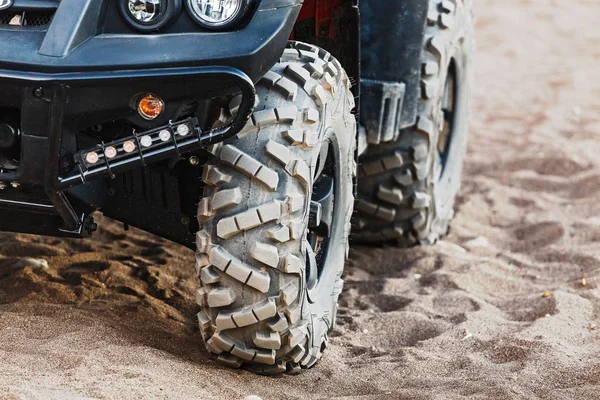 Off-road atv car closeup detail big tire, unrecognizable