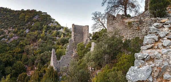 Big Ruined Fortress wall on a mountain over ancient city of Olympos in Chirali, Turkey