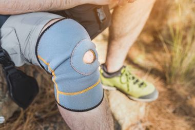 close up of knee support brace on leg of a traveler man during hiking outdoors in nature clipart