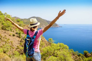 Genç kadın Gezgin Cliff'in kenarında duran ve bir Akdeniz manzarası, yaz tatil kavramı seyir sırt çantası ile