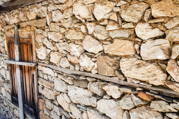 Stone wall of an old rustic house in village