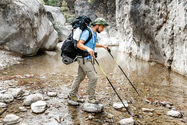Backpacker hombre vadeando pequeño río de montaña en el cañón de Goynuk, lycian manera, Turquía — Foto de Stock