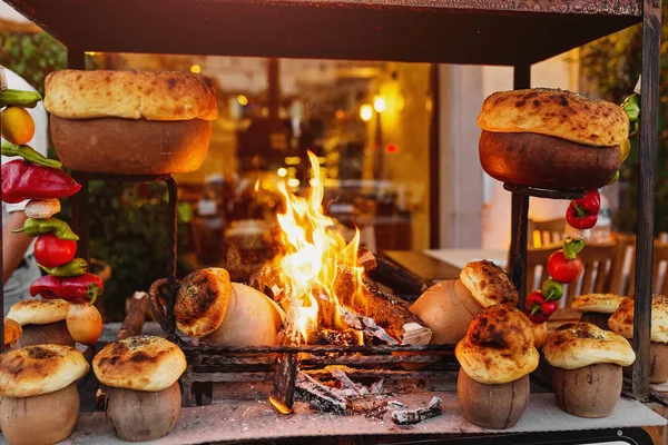 Traditional Turkish Testi Kebab cooked in clay pot on open fire at night in restaurant, authentic oriental cuisine — Stock Photo, Image