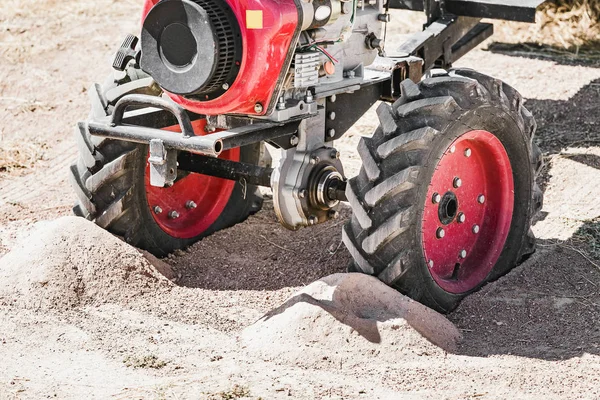 Der kleine handliche Landmaschinenmotorpflug in Großaufnahme, der in einer verlassenen ländlichen Landschaft im Sand steht — Stockfoto