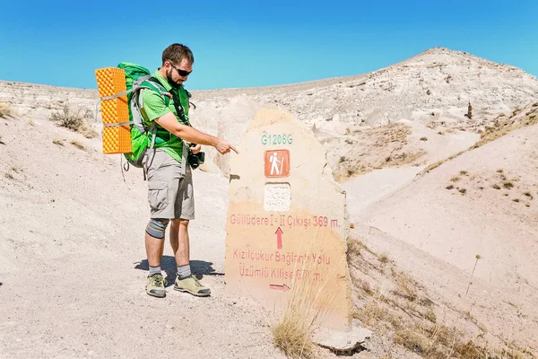 Senderismo punto hombre en la señal de dirección para los turistas de trekking en el valle de Capadocian Rose, Turquía — Foto de Stock