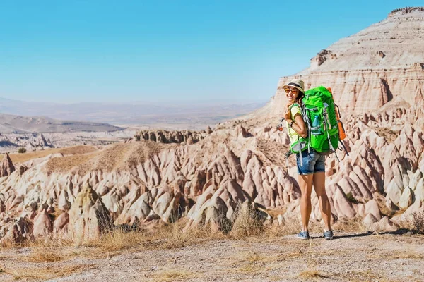 Unga glada aktiva turist kvinna med ryggsäck resor och vandringar på kappadokiska öde raviner och dalar, Turkiet. — Stockfoto