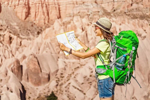 Giovane zaino in spalla turistico attivo viaggia tra cappadocia canyon di arenaria e città grotta in estate e mappa di lettura — Foto Stock