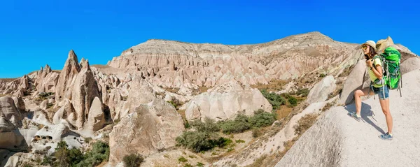 Ung glad kvinna traveler ensam vandring med ryggsäck i grottan staden i rose valley Cappadocia, Turkiet — Stockfoto