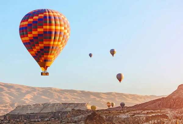 Colorido globo aerostático volando sobre el paisaje rocoso en Capadocia Turquía —  Fotos de Stock