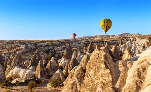 Colorido globo aerostático volando sobre el paisaje rocoso en Capadocia Turquía — Foto de Stock