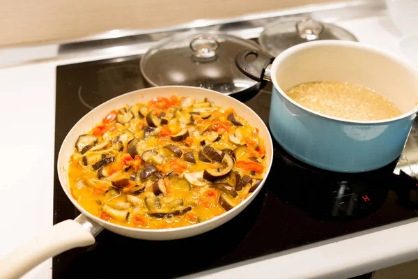 Frying pan with stew vegetables on a stove in a kitchen — Stock Photo, Image