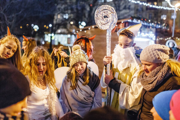 PRAGUE, CZECH REPUBLIC - DECEMBER 2017: Dressed in the costumes of devils and angels and St. Nicholas, children celebrate Christmas and have fun on the main square of the city