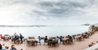Eylül 2017, Istanbul, Türkiye: İnsanlar, boğaz ve deniz manzaralı bir restoran yemek
