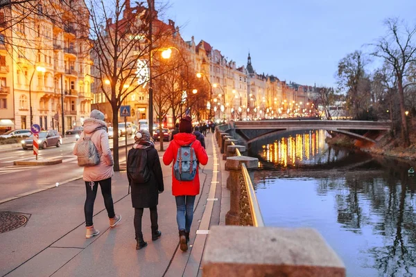 Touristes marchant dans les rues hivernales de Prague avec vue sur le pont Vlatva — Photo
