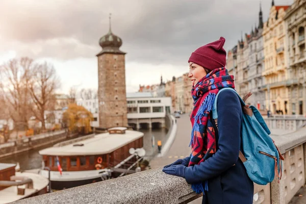 Turistické žena v plášti s batohem cestuje v městě Praha — Stock fotografie