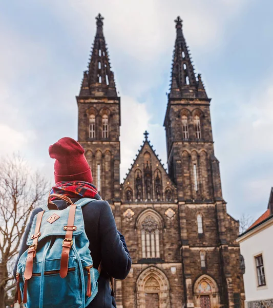 Pretty young female tourist with backpack looking at majestic Basilica of St. Peter and Paul in Prague — Stock Photo, Image