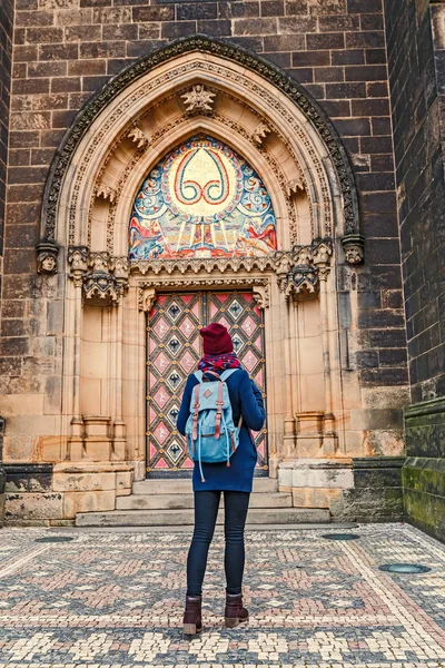 Pretty young female tourist with backpack looking at majestic Basilica of St. Peter and Paul in Prague — Stock Photo, Image