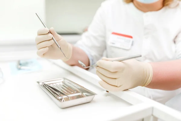 Mani che tengono gli strumenti dentali nell'armadio di stomatologia — Foto Stock