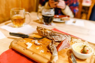 Hazırlanmış bir çek bira ve geleneksel sosis ve domuz eti beyaz tabakta fincan çubuk veya Restoran
